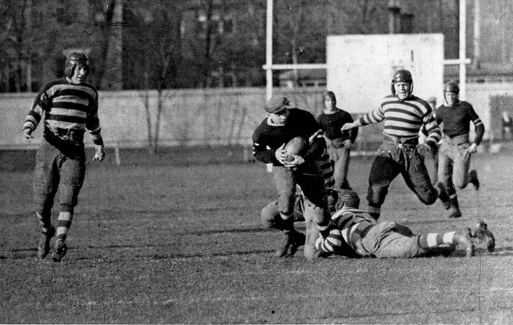 Toronto Argonauts (stripes) versus Ottawa Rough Riders (solids) at Varsity Stadium. The ball carrier is Harry Hutchingham for Ottawa. Toront